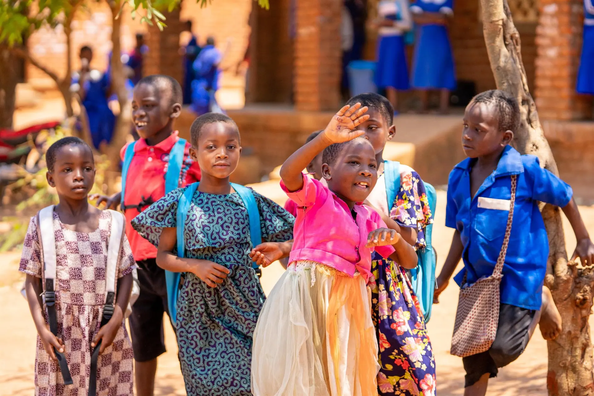 Malawian children in colourful clothes, waving